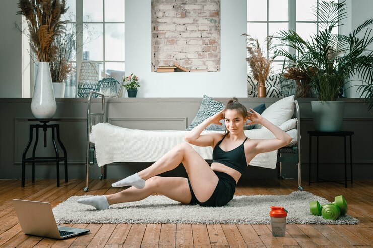 Photo femme athlétique positive avec des cheveux bien attachés et des vêtements de sport serrés faisant presse à la maison.
