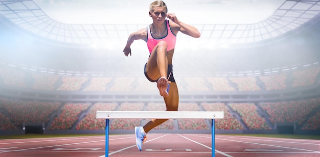Femme athlétique pratiquant le saut d'obstacles contre la vue d'un stade