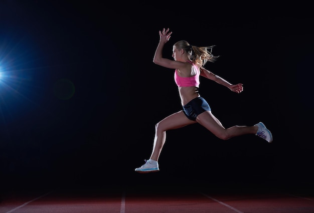 Femme athlétique qui court sur la piste de course