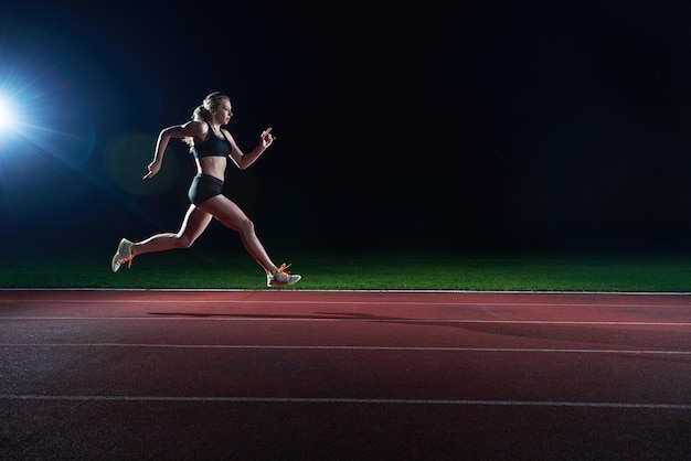 Femme athlétique qui court sur la piste de course