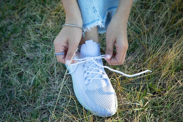 Femme attachant des lacets de chaussures en plein air