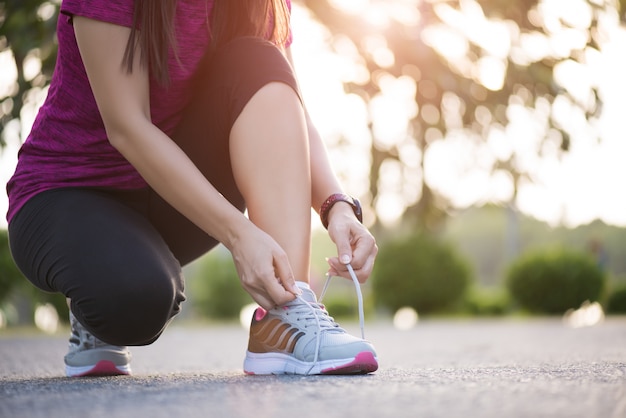 Femme attachant des lacets de chaussures prêts pour le jogging dans le jardin