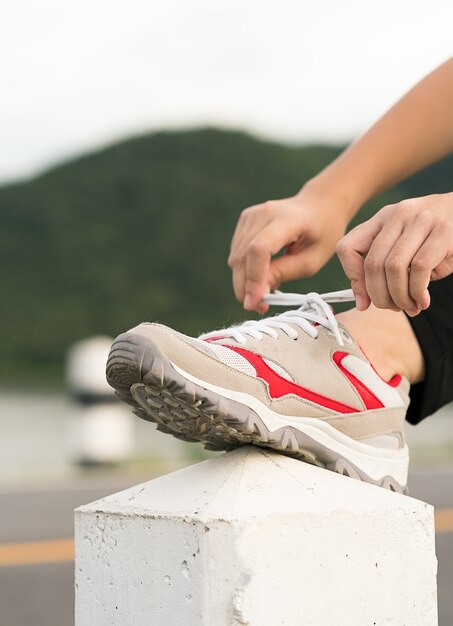 Femme attachant son lacet avant de commencer à courir