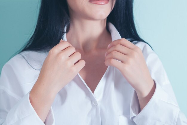 La femme attache le bouton de la chemise