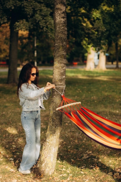 Photo une femme attache un hamac à un arbre.