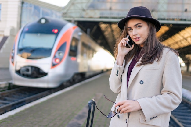 Femme en attente de train sur le quai de la gare