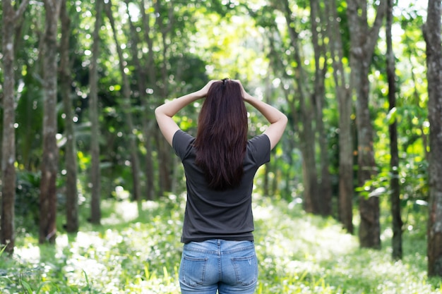 Une femme attrape ses cheveux avec confusion après avoir perdu son chemin dans la forêt