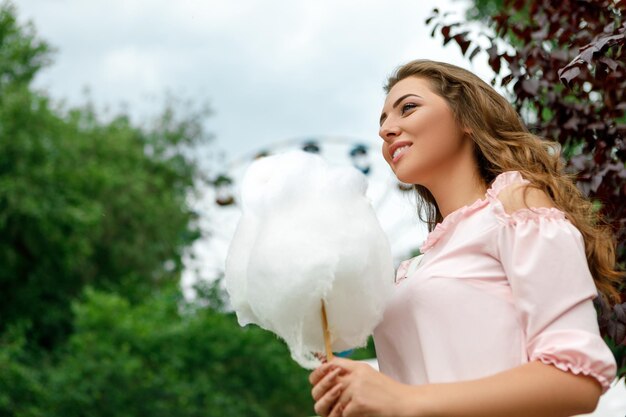 Photo une femme attrayante tenant un coton sucré sucré