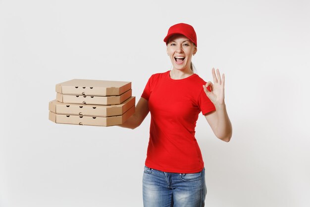 Femme au bonnet rouge, t-shirt donnant des boîtes à pizza pour commande de nourriture isolées sur fond blanc. Pizzaman féminin travaillant comme coursier ou revendeur tenant une pizza italienne dans une boîte plate en carton. Concept de service de livraison.