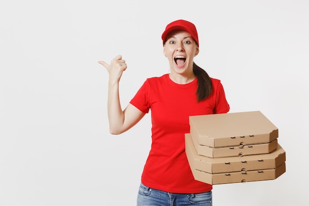 Femme au bonnet rouge, t-shirt donnant des boîtes à pizza pour commande de nourriture isolées sur fond blanc. Pizzaman féminin travaillant comme coursier ou revendeur tenant une pizza italienne dans une boîte plate en carton. Concept de service de livraison.