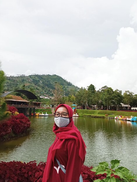 Photo une femme au bord d'un lac contre le ciel