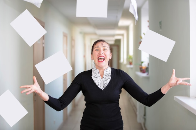 Une femme au bureau disperse des papiers.