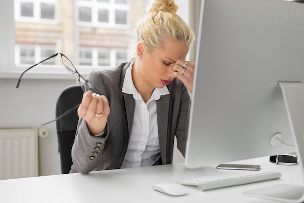 Femme au bureau les yeux au repos