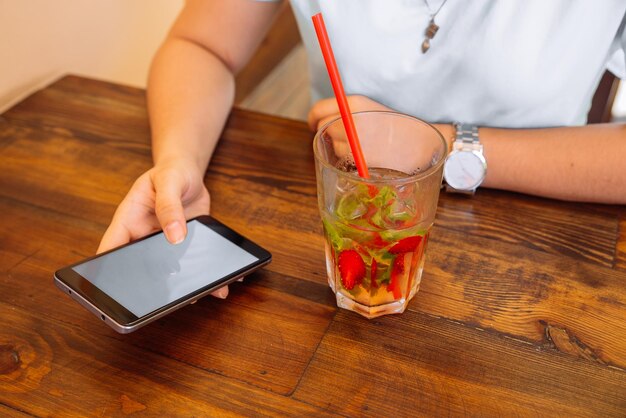 Femme au café buvant des boissons fraîches en gros plan