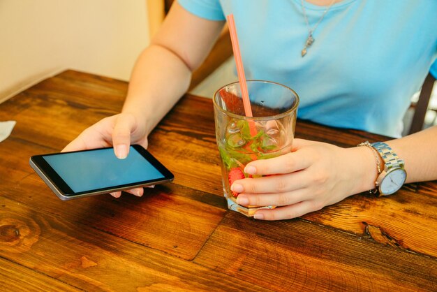 Femme au café buvant des boissons fraîches en gros plan