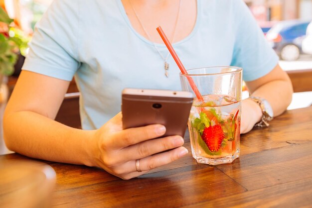 Femme au café buvant des boissons fraîches en gros plan