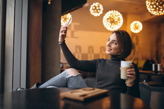 Femme au café faisant selfie et boire du café