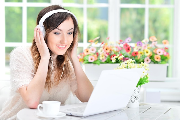 Femme au casque à l'aide d'un ordinateur portable