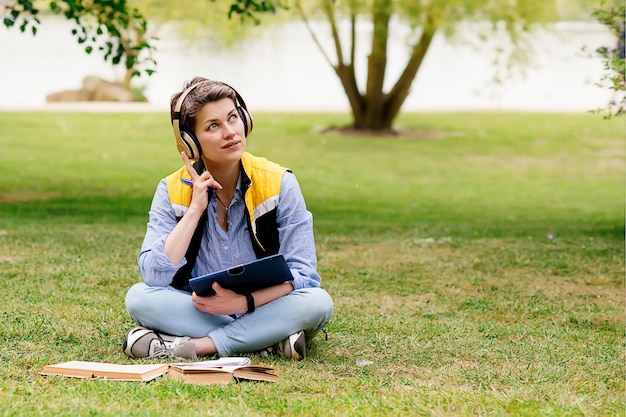 Femme au casque assis sur l'herbe verte