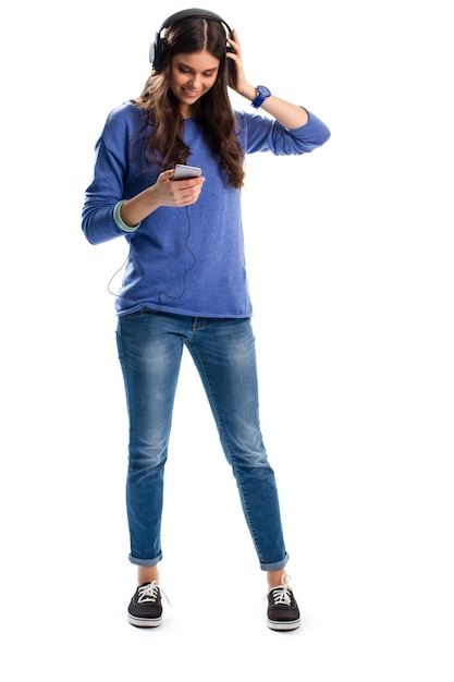 Femme au casque souriant. Dame en sweat-shirt tient le téléphone. Nouveaux écouteurs de marque célèbre. Meilleure qualité de son.