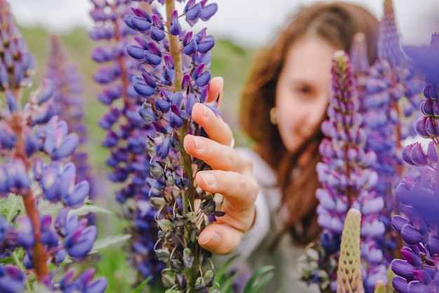 Femme au champ de lupins en fleurs