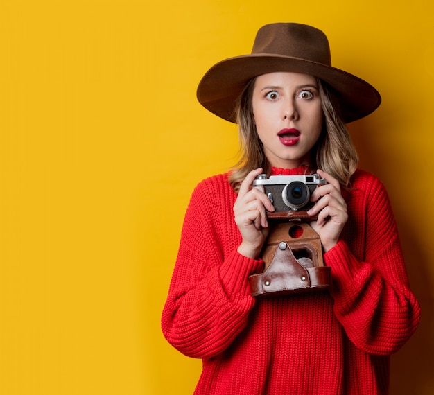 Femme au chapeau avec appareil photo vintage