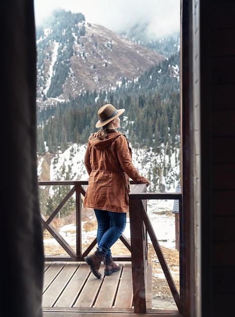 Femme au chapeau au chalet dans les bois