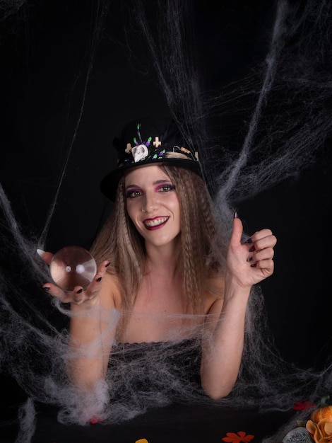 Femme au chapeau avec boule de cristal en riant