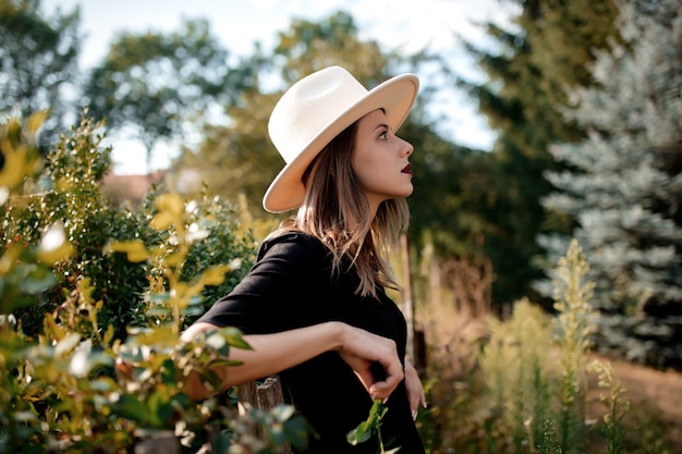 Femme au chapeau dans un jardin de campagne d'été