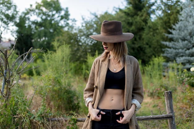 Femme au chapeau dans un jardin de campagne d'été