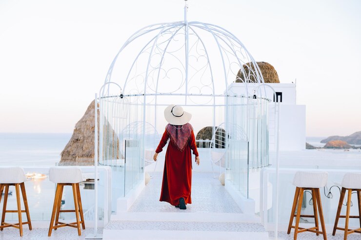 Femme au chapeau d'été marchant sur le toit avec vue sur la mer