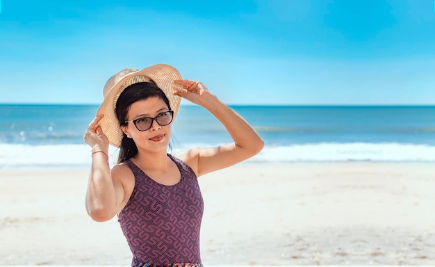 Femme au chapeau heureux sur la plage heureuse jolie jeune femme sur le concept de vacances vacances