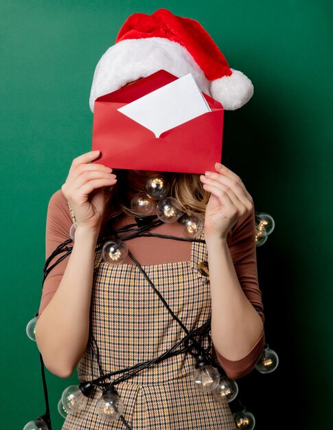 Photo femme au chapeau de noël et courrier dans une enveloppe