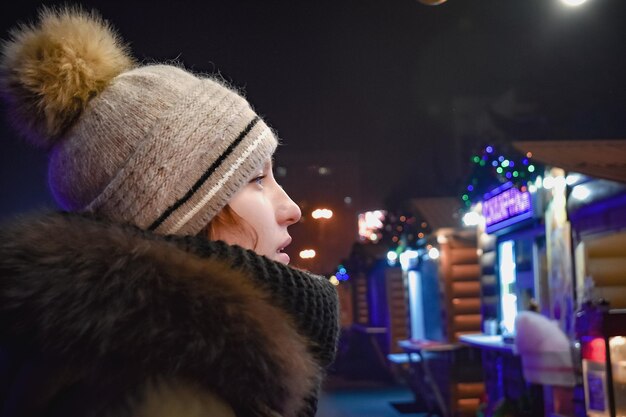 Une femme au chapeau regarde une devanture avec une pancarte qui dit "je t'aime"