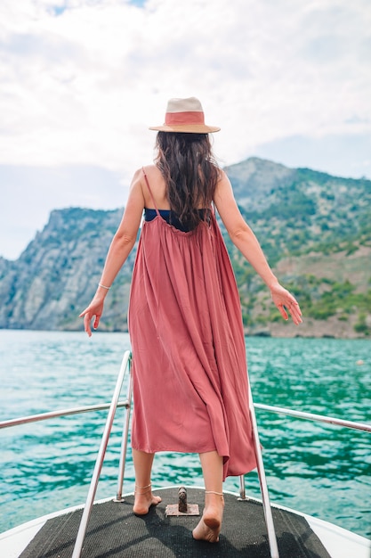 Femme au chapeau et robe voile sur bateau en pleine mer claire