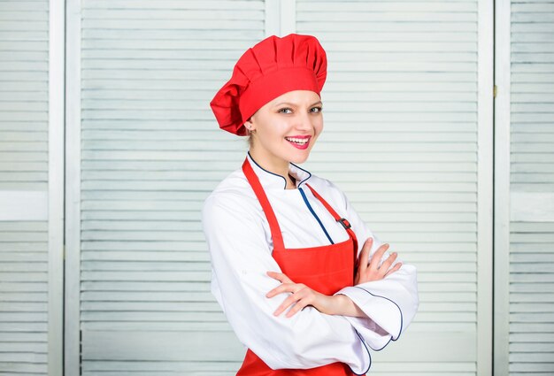 Femme au chapeau et tablier de cuisinier. chef professionnel en cuisine. Cuisine. femme heureuse cuisiner des aliments sains par recette. Femme au foyer avec ustensile de cuisine. Technologie utile. Présentation de la nourriture.