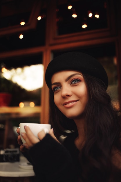 Femme au chapeau avec une tasse de café