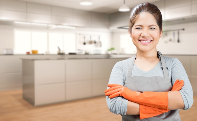 Femme au foyer asiatique portant des gants en caoutchouc avec fond de cuisine