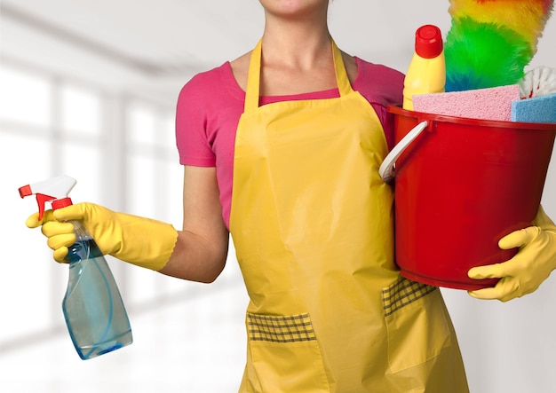 Femme au foyer belle jeune femme avec des produits de nettoyage