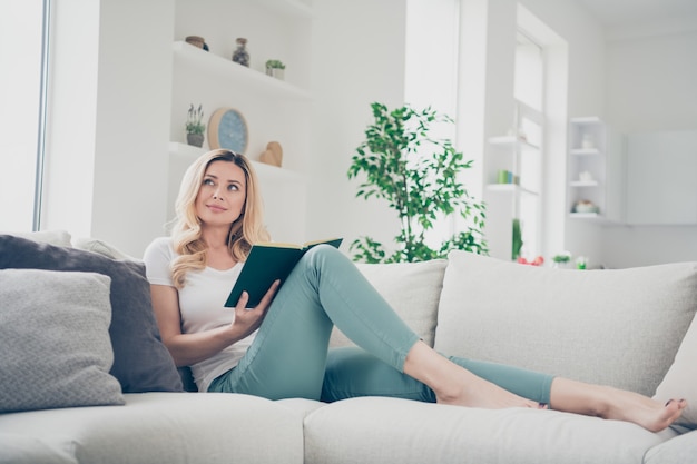 Femme au foyer domestique profil dame se détendre couché confortable canapé rester à la maison lire livre rêve