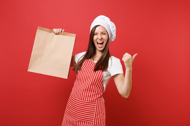 Femme au foyer femme chef cuisinier boulanger en tablier rayé t-shirt toque chapeau de chef isolé sur fond de mur rouge