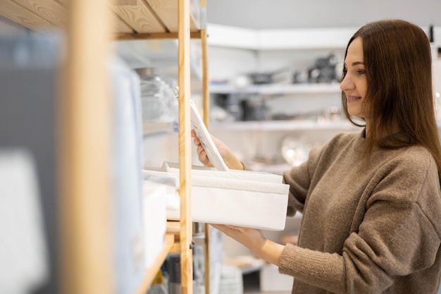 Femme au foyer moderne choisissant des conteneurs pour l'organisation de stockage d'armoires domestiques profitant du shopping