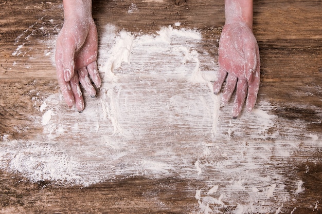 Femme au foyer préparant du pain ou une tarte dans sa cuisine à domicile. Les mains couvertes de farine. Cuisiner pour la famille