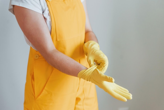 Femme au foyer en uniforme jaune se préparant à polir les fenêtres à l'intérieur Conception de rénovation de maison