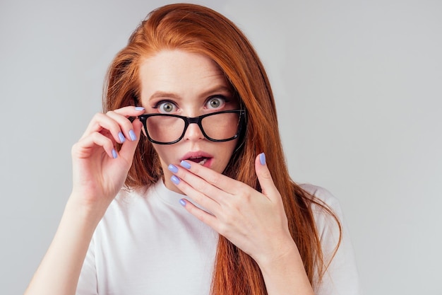 Une femme au gingembre rousse ennuyeuse ressentant de l'irritation et de la colère sur fond de studio.