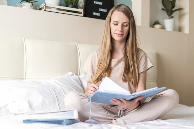 Femme au lit avec des cahiers