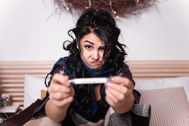 Femme au lit avec une écharpe à haute température