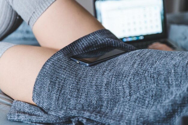 Femme au lit avec ordinateur portable et smartphone en mains. concept de mode de vie