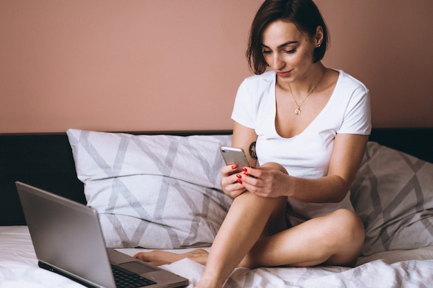 Femme au lit avec un téléphone