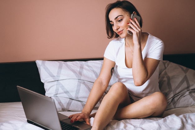 Femme au lit avec un téléphone